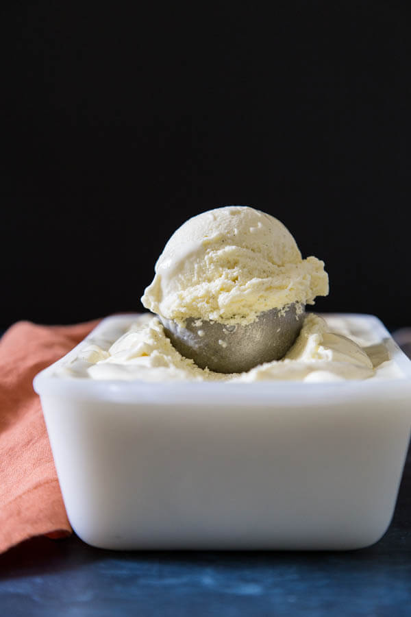 A scoop of lactose free ice cream on top of the ice cream container