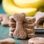 Peanut butter banana dog treats propped up on a green table top.