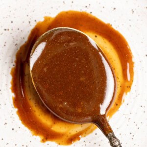 A spoon of homemade dulce de leche on a plate.