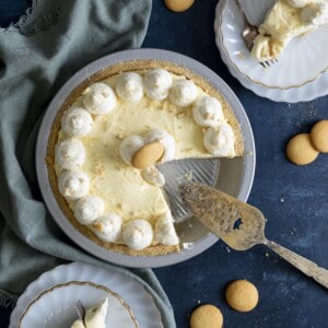 Banana cream pie in a pie dish with slices on white plates.