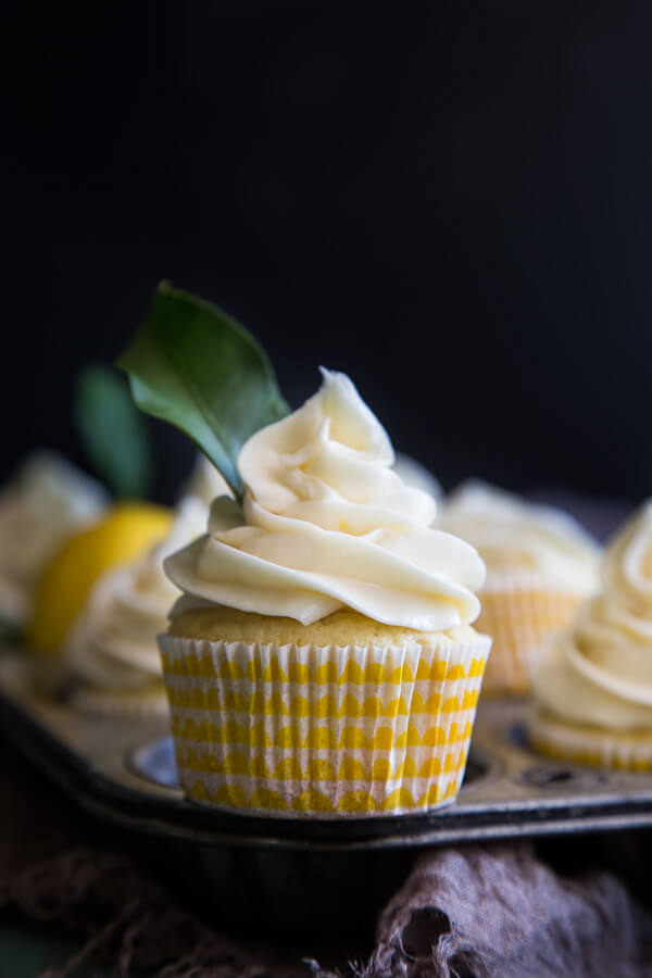 A lemon cupcake garnished with a lemon leaf