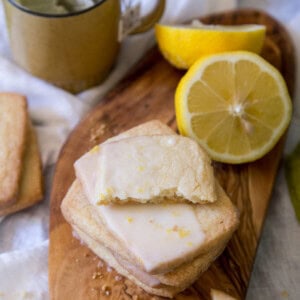 Lemon Shortbread Cookies on a wooden board with lemon halves