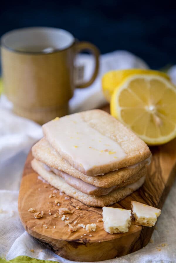Lemon Shortbread Cookies on a wooden board with lemon halves