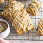 Homemade PB&J pop tarts with glaze and sprinkles on a wire rack.