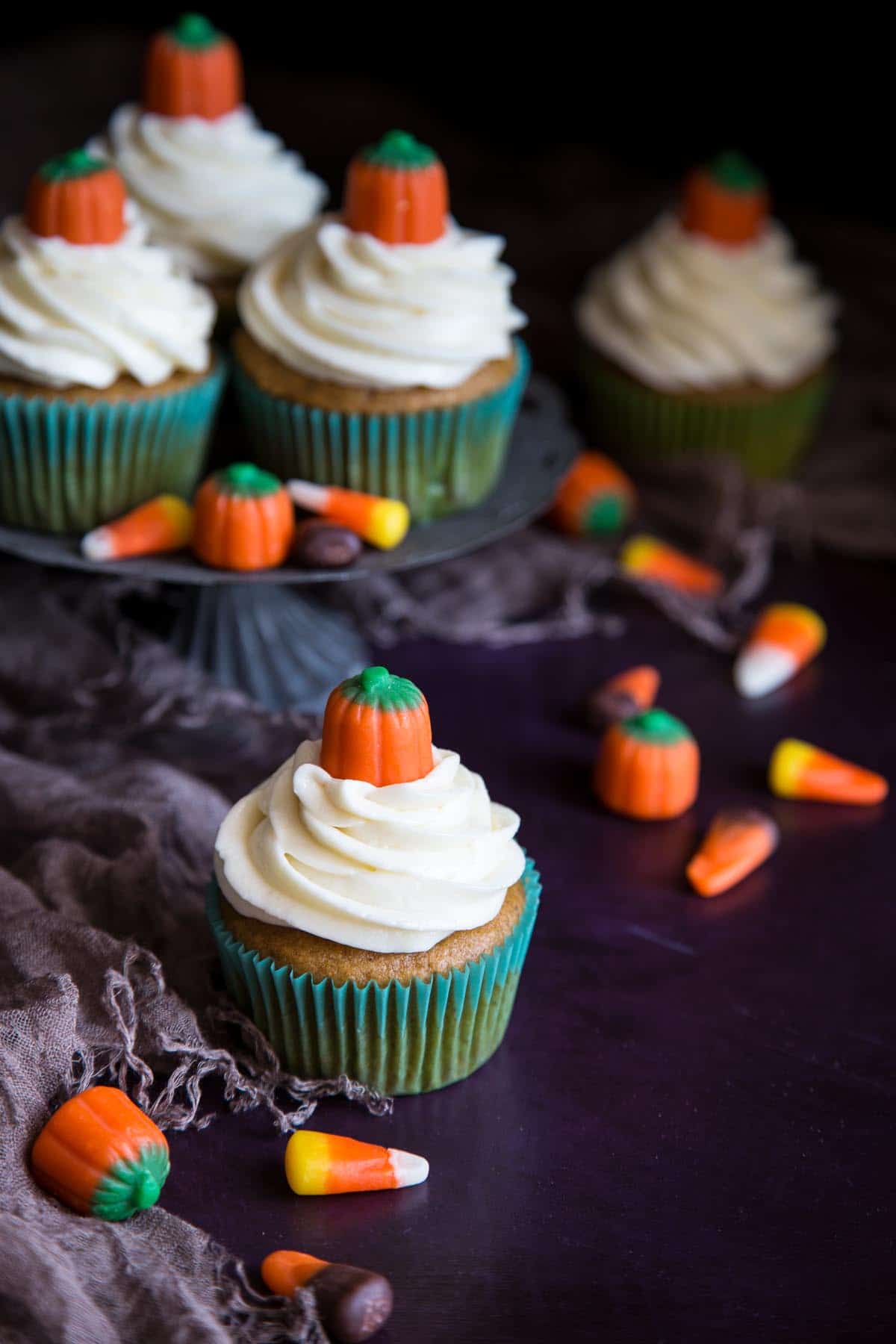 Pumpkin cupcakes with cream cheese frosting decorated with mellowcreme pumpkins.