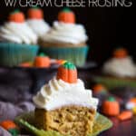 A half eaten pumpkin cupcake with cream cheese frosting and pumpkin mellowcreme.
