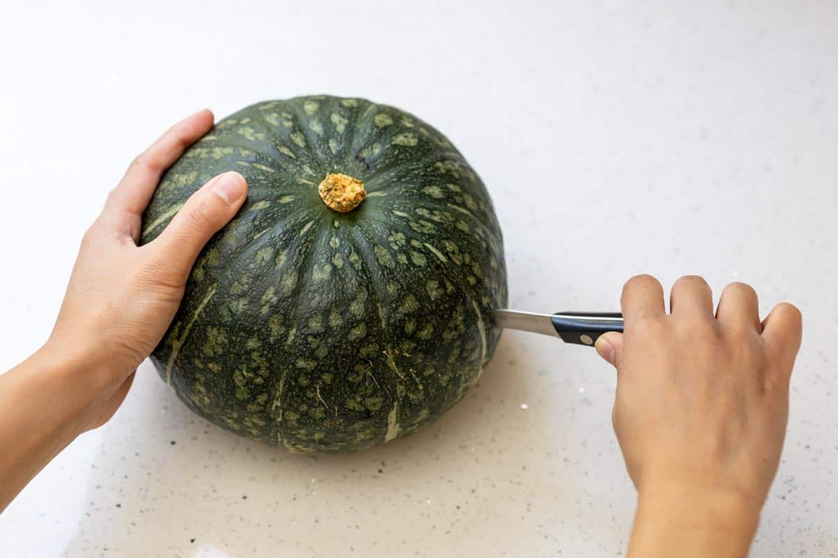 Piercing a kabocha pumpkin with a knife.