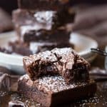 A half eaten slice of dark chocolate brownie