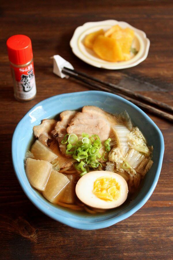 A bowl of ramen with chashu, daikon, cabbage, green onion and half an egg