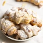 A small plate of marzipan rugelach on a marble surface.