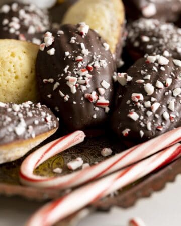 A tray of vanilla madeleines dipped in chocolate and garnished with peppermint candies.