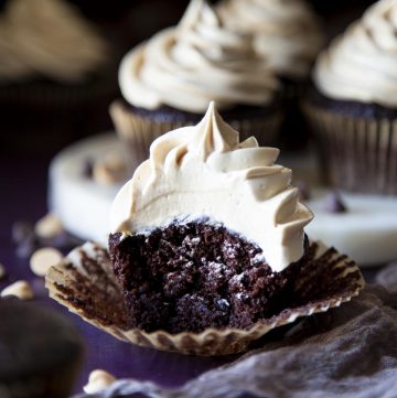 A chocolate cupcake with peanut butter frosting, with a bite taken out of it.