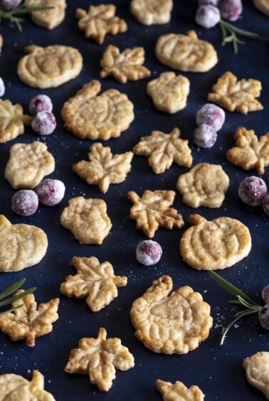 Pie crust cookies of different shapes on a dark surface.