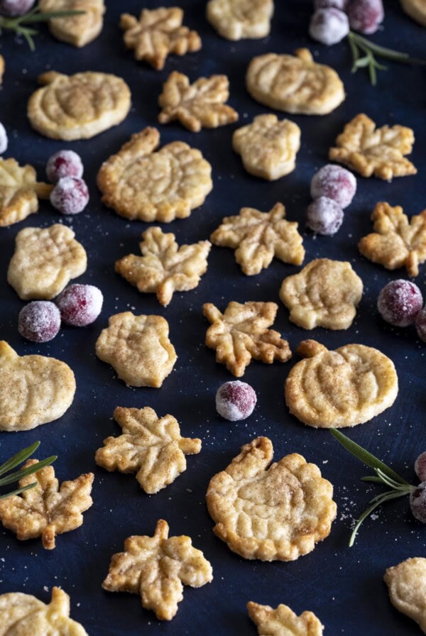 Pie crust cookies of different shapes on a dark surface.