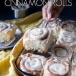 A cinnamon roll being lifted from the pan.