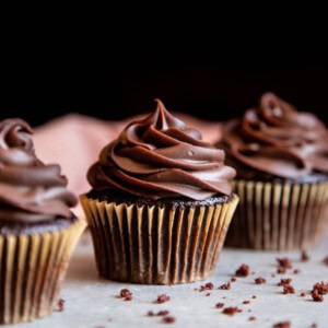 Three chocolate cupcakes standing in a line