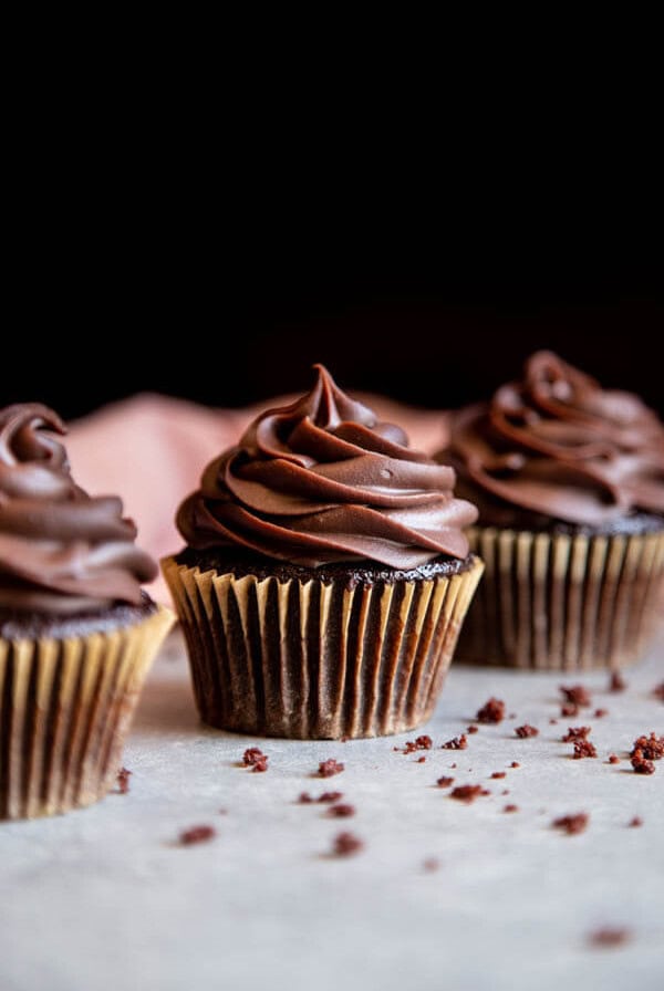 Three chocolate cupcakes standing in a line