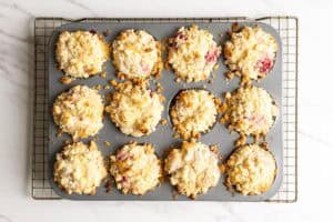 Raspberry White Chocolate Chip Muffins are baked and resting on a wire rack.