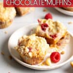 Raspberry white chocolate muffins on a white plate with raspberries and macadamia nuts sprinkled around.