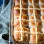 Orange cranberry hot cross buns in a glass baking dish