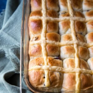 Orange cranberry hot cross buns in a glass baking dish