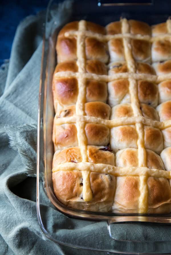 Orange cranberry hot cross buns in a glass baking dish