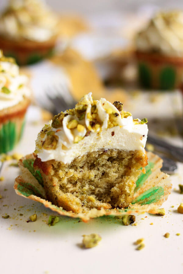 A delicious bite of these Pistachio Cupcakes with Orange Mascarpone Frosting | wildwildwhisk.com
