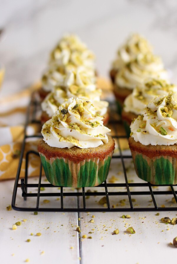 Pistachio cupcakes on a wire rack.