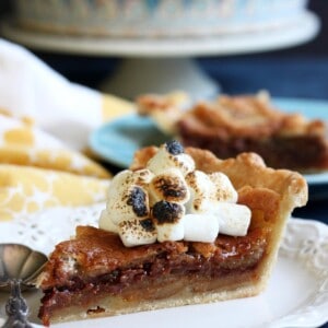 A slice of s’mores pie with toasted marshmallows on top.
