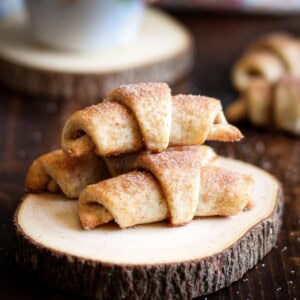 Cinnamon Roll Rugelach stacked on a wooden coaster.