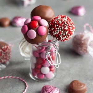 Strawberry truffles on a stick in a small jar.