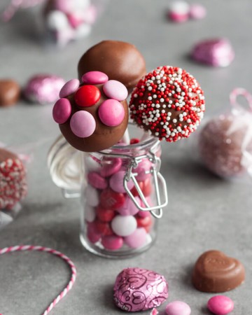 Strawberry truffles on a stick in a small jar
