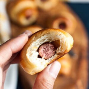 A hand holding a half eaten mini pig in a blanket