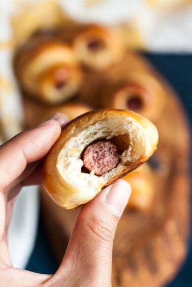 A hand holding a half eaten mini pig in a blanket