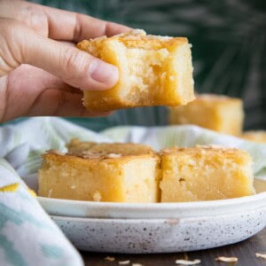 Holding up a half eaten slice of Hawaiian Butter Mochi.