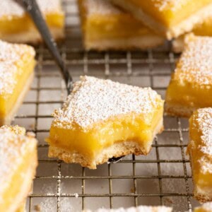 A square of lemon bar with a bite taken out of the corner.