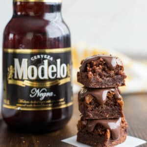A stack of Spicy Stout Brownies next to a bottle of Modelo Negra