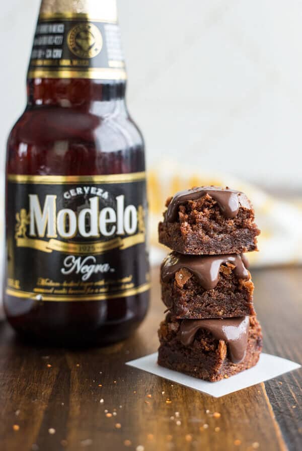 A stack of Spicy Stout Brownies next to a bottle of Modelo Negra