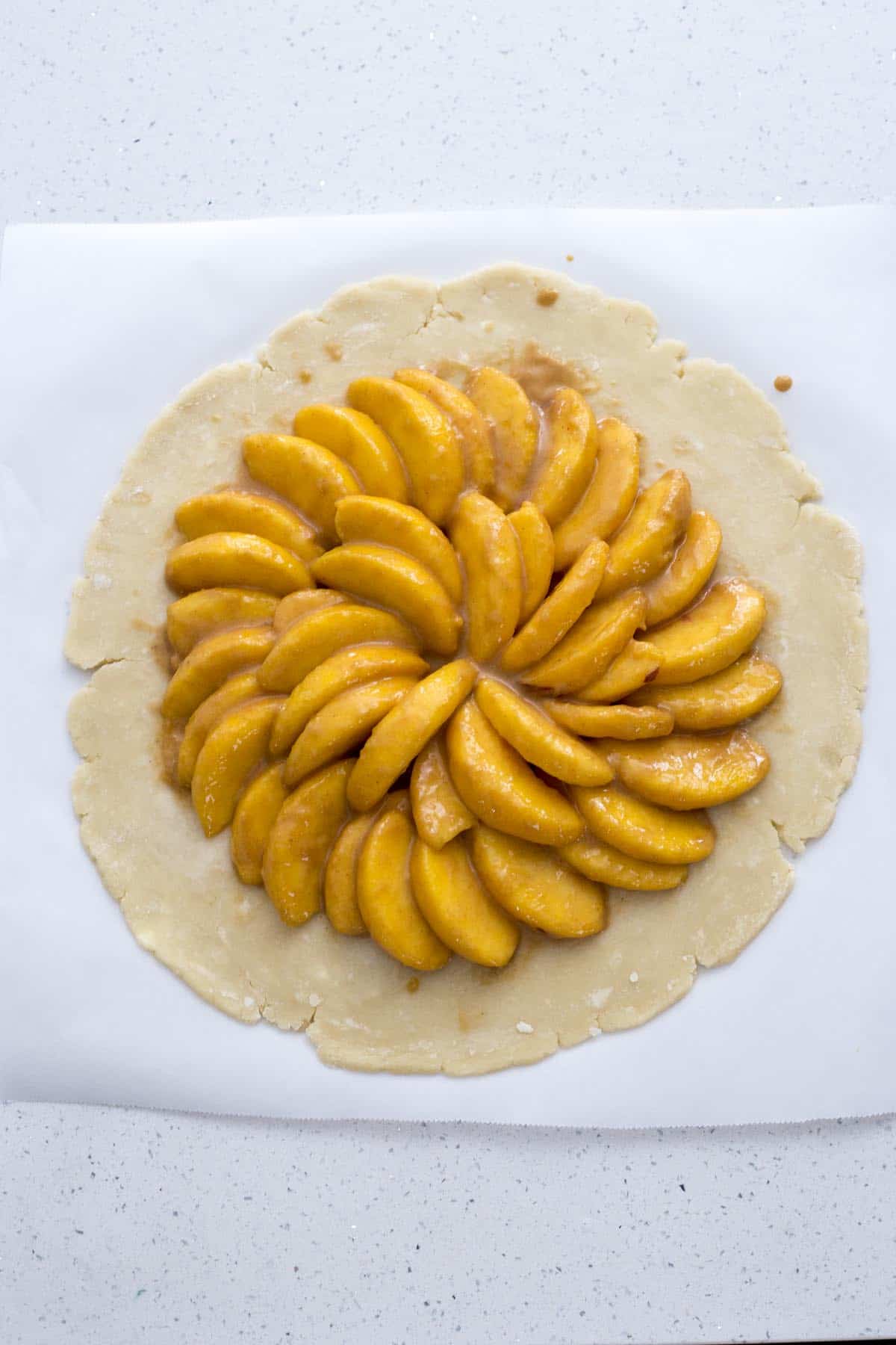 Added sliced peaches to pie dough.