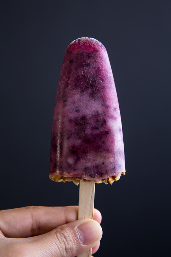 Blueberry Popsicles against a black background