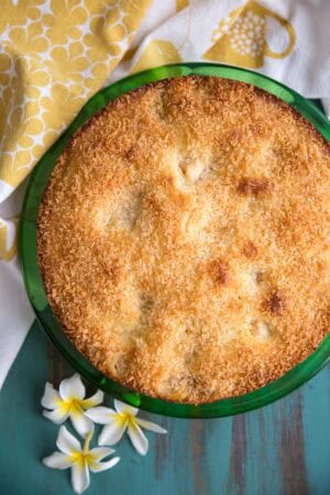 A baked coconut mango cake on a green plate.