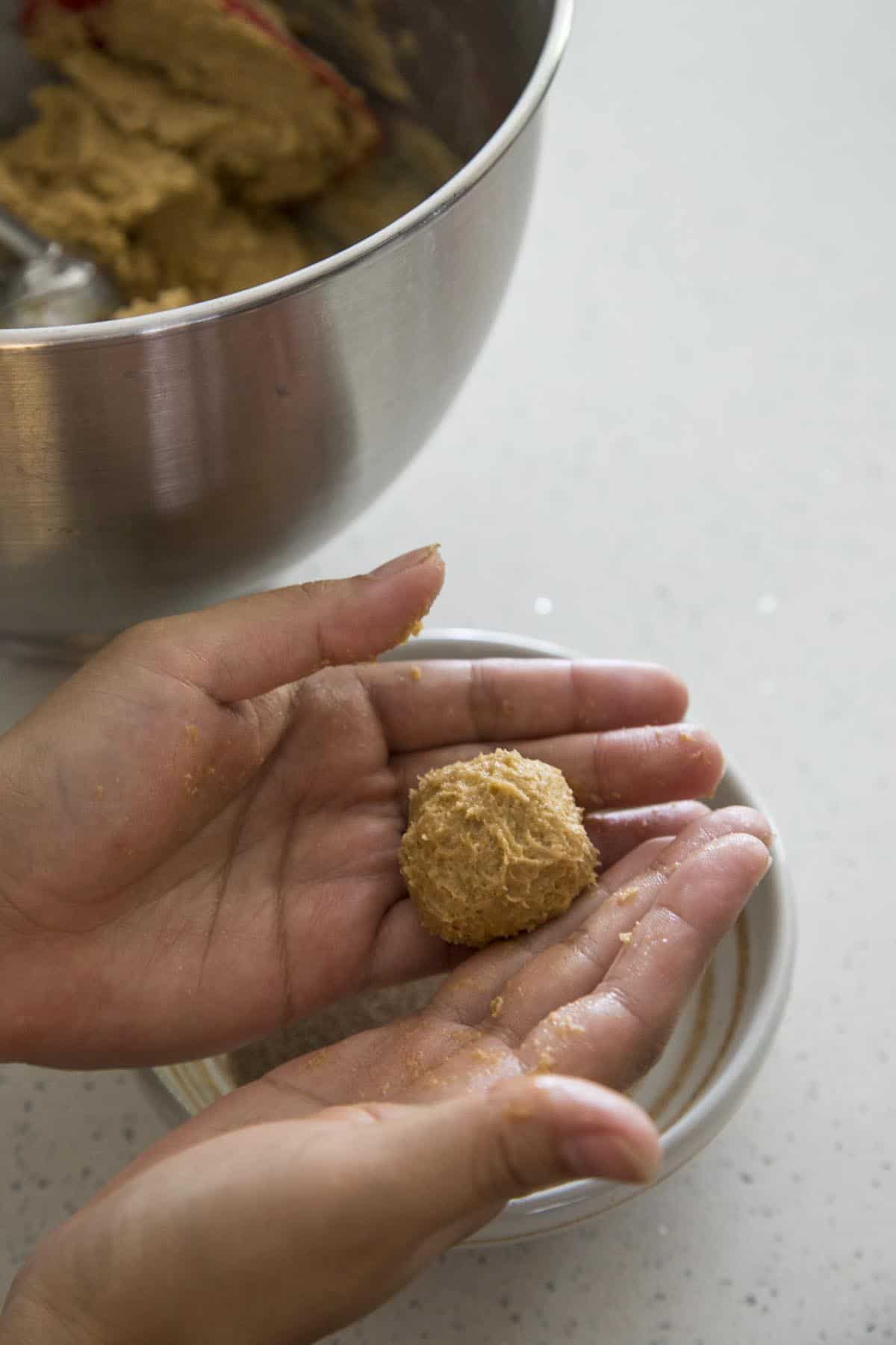 Rolling cookie dough into balls.
