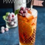 A glass of winter Pimm's cup garnished with sugared cranberries.