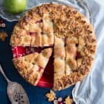 A pear cranberry pie with lattice top crust in a red pie dish.