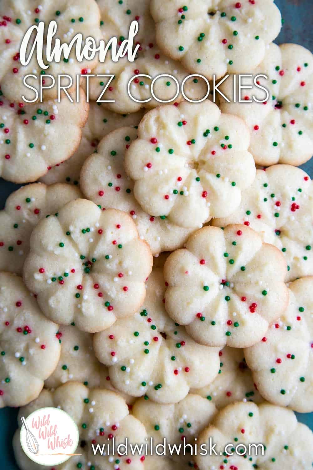 This Almond Spritz Cookie Recipe is so easy to make. The cookies can be piped into any festive shapes for the holiday. #wildwildwhisk #spritzcookies #spritzcookierecipe #almondspritz #christmascookies #christmascookieexchange #christmascookierecipe #almondcookies #almond #cookiepress