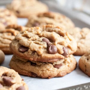 A stack of two peanut butter chocolate chip cookies on a baking sheet