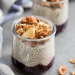 Coconut Chia Pudding with berry compote and granola in glass jars.