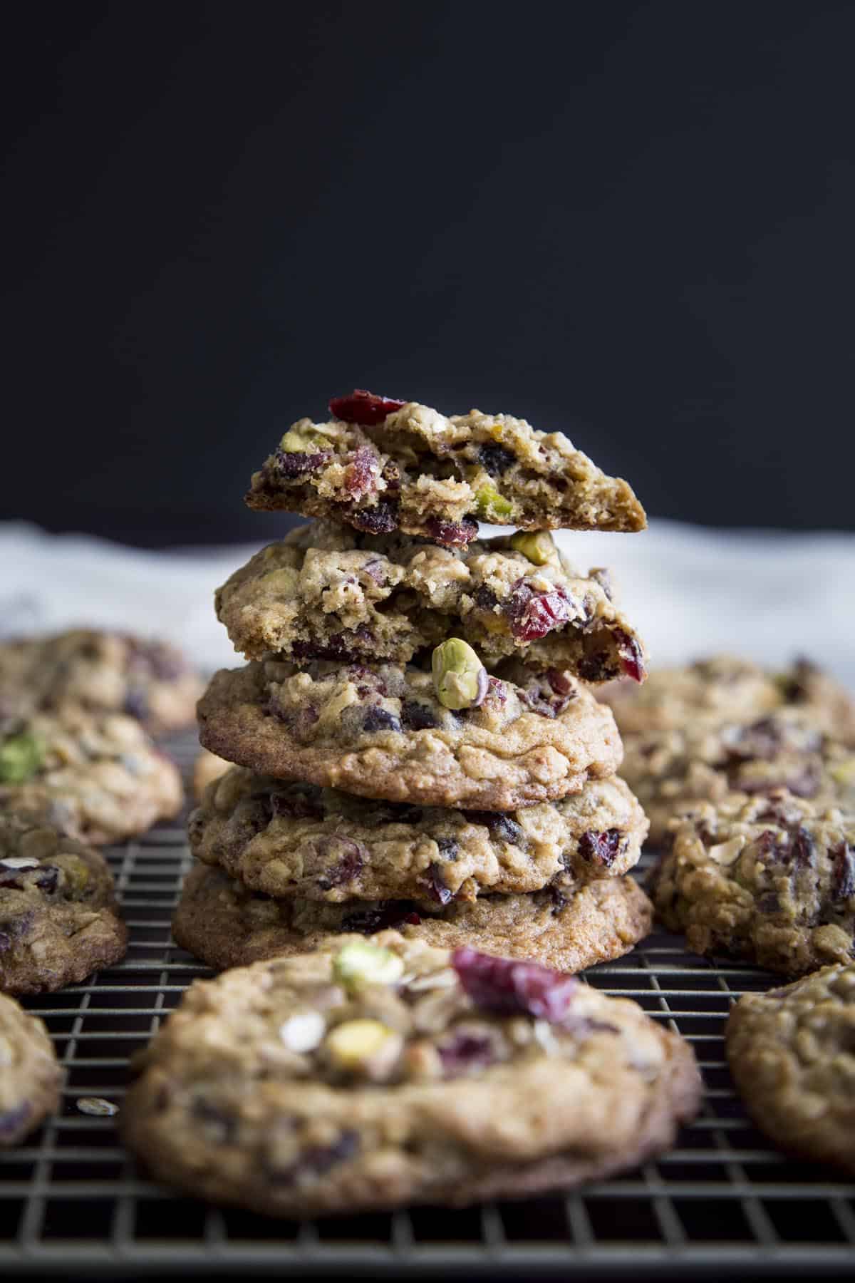 A stack of pistachio oatmeal cranberry cookies, the top one is broken in half