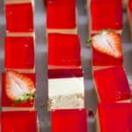 Strawberry Jello Cream Cheese Dessert cut into squares.