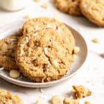 Oatmeal mango cookies on a plate, some cookies and crumbs are scattered around.